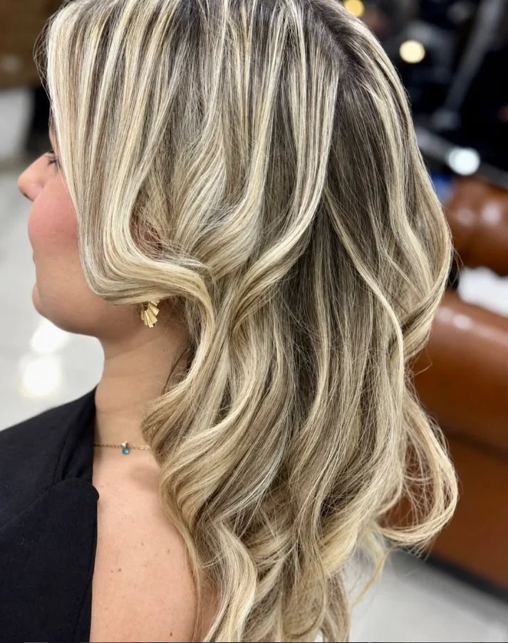 Cabelo loiro com mechas claras e ondas, resultado enviado pelo Studio Elegância